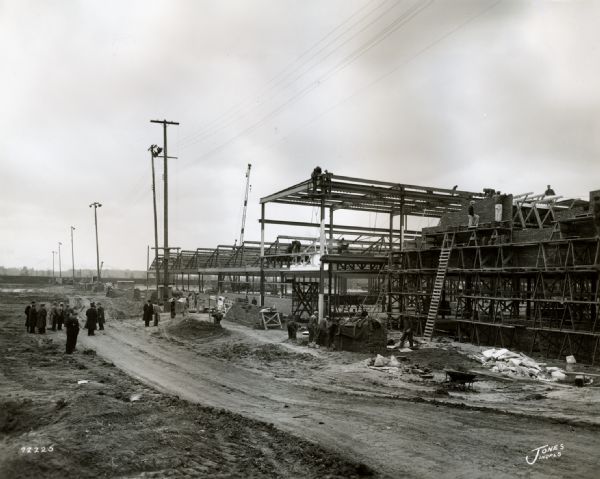 Men inspect the construction of International Harvester's Indianapolis Truck Engine Works. The original caption reads: "Photo taken during the inspection of the Indianapolis Truck Engine Works, then under construction. Present on the tour were Harvester officials, Indianapolis businessmen and city and state officials."