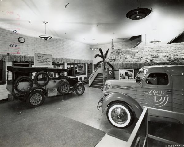 International Harvester showroom (possibly part of a dealership or branch house) in Manhattan. The showroom featured an exhibit on an Attilio Gatti expedition to Africa. The exhibit included a ten-year-old International truck, the first to cross the Sahara desert. The sign above the truck reads: "10 years ago Sir Charles Markham and Baron Buxen-Finecke crossed the Sahara Desert in this International truck - First stock 4-wheel motor vehicle to accomplish this feat!"