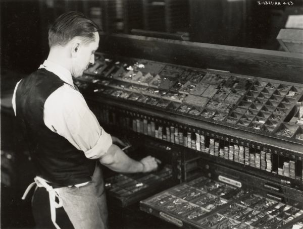Man selecting metal type, possibly at Harvester Press.