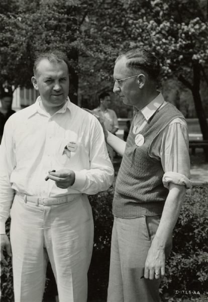 International Harvester employees on a golf course. The employees are M.F. Peckels (left), supervisor of national fleet sales, and M.F. McCarty, manager of the Chicago truck branch.