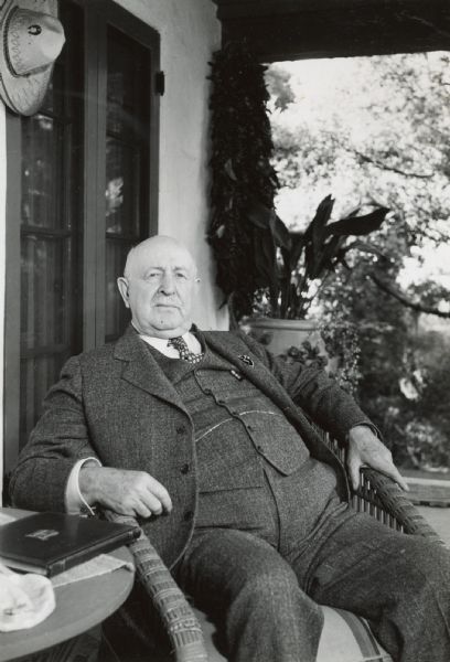 C.H. Haney, former manager of foreign sales, sits in a wicker chair outside of his home.