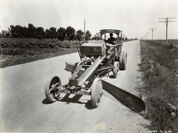 A man uses a Gilbert road grader with a twenty foot blade to work on the Yellowstone Trail.