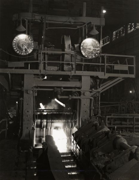 Blooming mill at International Harvester's Wisconsin Steel Works. Original caption reads: "Closeup of ingot entering rolls of 40" blooming mill with finished blooms in background."
