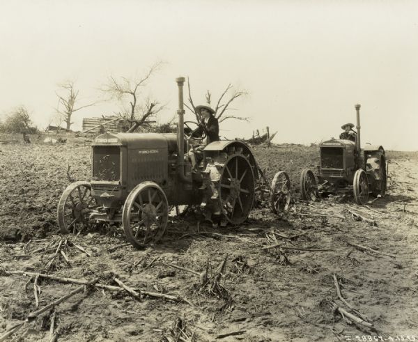 Two women using McCormick-Deering relief tractors in a field damaged by the "tri-state tornado." The tractors appear to be 10-20s.