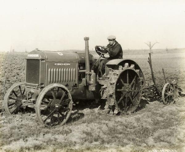 A man using a McCormick-Deering relief tractor to work in a field affected by the "tri-state tornado." The tractor appears to be a 10-20.