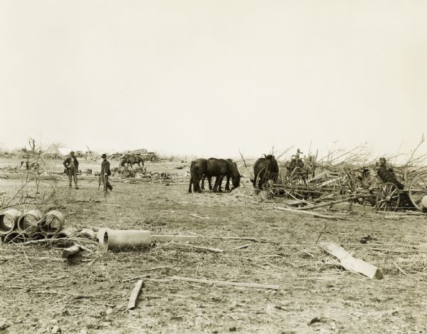 Men and horses walk through an area damaged by the "tri-state tornado."
