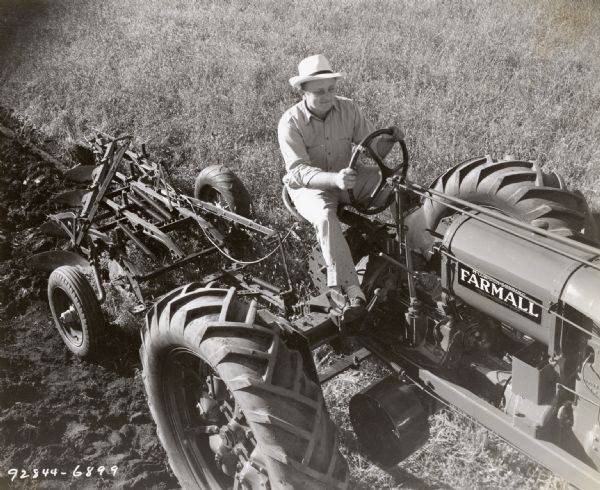 Elevated view of Dalen Kramer using a McCormick-Deering Farmall F-30 tractor to work in a field.