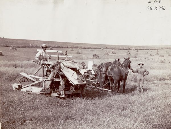 Side view of two men using a McCormick twine self-binding harvester pulled by three horses. The original photograph caption reads: "This machine represents the modern harvester by which grain is automatically bound with twine, in bundles of uniform size, and discharged on the ground."