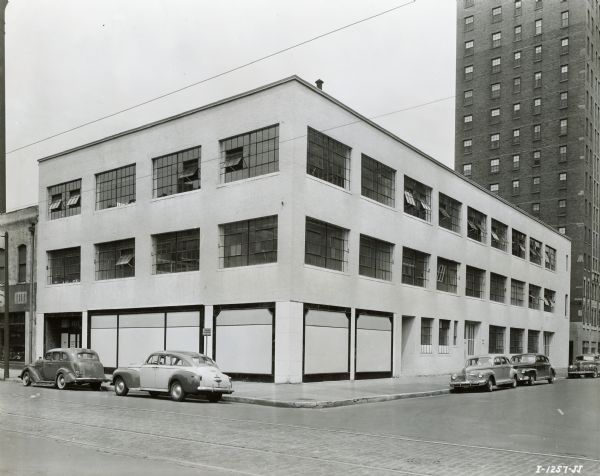 Exterior view of International Harvester's Education and Training Center.  Cars are parked along the surrounding streets.