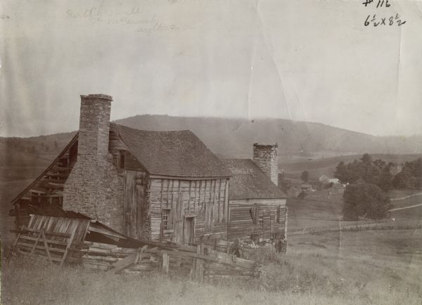 Run-down building with a stone chimney in a rural landscape. The photograph is identified as "Steele's Tavern." Cyrus McCormick successfully demonstrated his reaper at Steele's Tavern in July of 1831.
