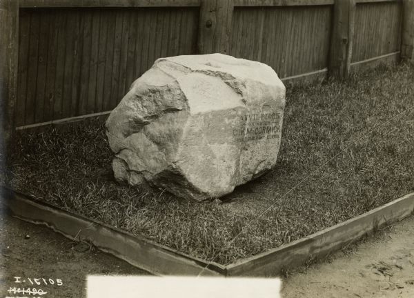 Large stone identified as the anvil block upon which Cyrus McCormick built the first reaper. The stone is likely on the grounds of International Harvester's McCormick Works.
