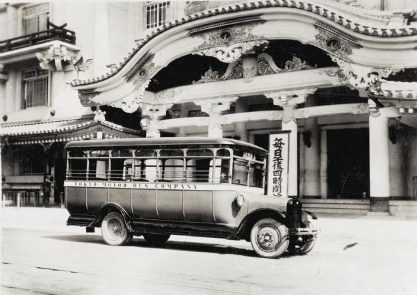 An International bus marked: "Tokyo Motor Bus Company" parked in front of a Kabuki Theater in Tokyo, Japan. The original caption reads: "Kabuki Theatre, Tokyo, Japan. Best one in Japan - Model S.L. bus in front."