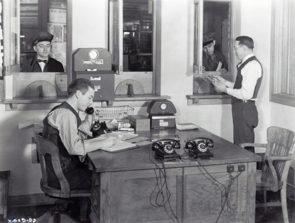 Workers for the American Transportation Company in a highway dispatcher's office.