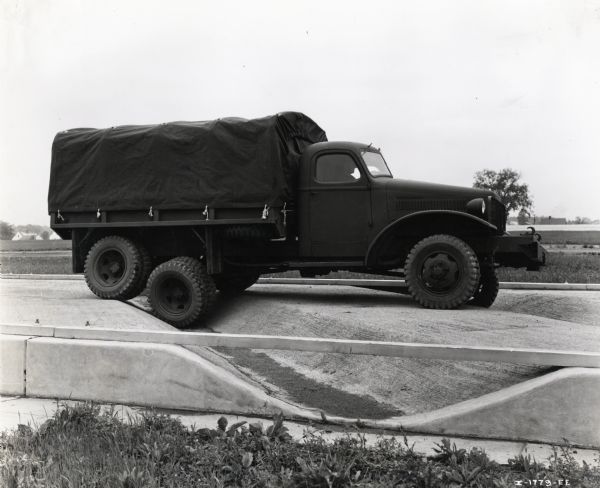 An International M-5-6 truck on a test drive along a concrete track with deep depressions at the Fort Wayne Proving Grounds. The original caption reads, "International M-5-6 pilot model being tested before delivery to army."