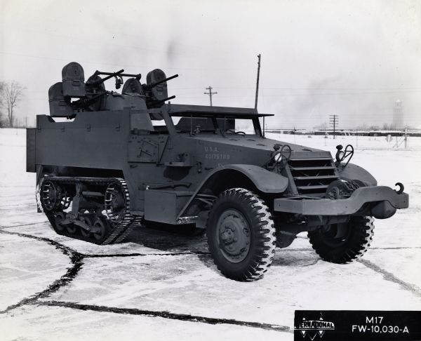 Side view of a military half-track manufactured by the International Company parked in a snow-covered lot. The vehicle bears the mark "U.S.A. 40175789." The inset in the bottom right corner reads: "International M17, FW-10, 030-A."