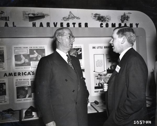 Donald M. Nelson, chairman of the War Production Board, speaks to W.O. Maxwell of the Consumer Relations Department and chairman of the Exhibitors' Committee at the First National Labor-Management Production Exposition. The exposition was held in the Department of Commerce Building and it opened on February 28.