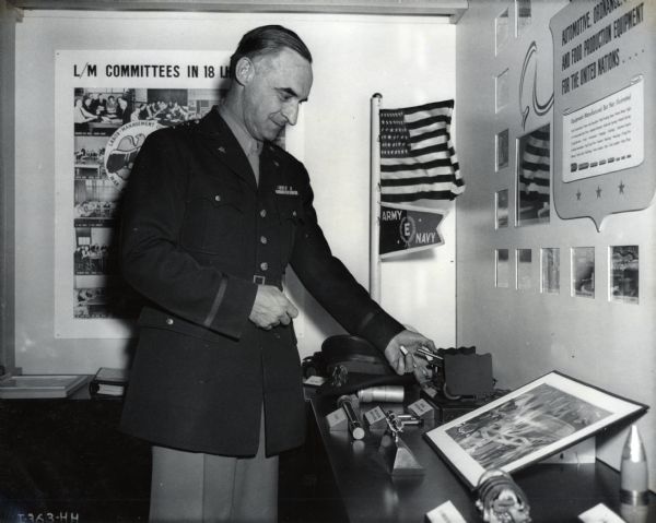 Major General Lucius D. Clay, Director of Material, U.S. Army, examines a scale model of the 57-millimeter gun at the International Harvester exhibit at the First National Labor-Management Production Exposition.