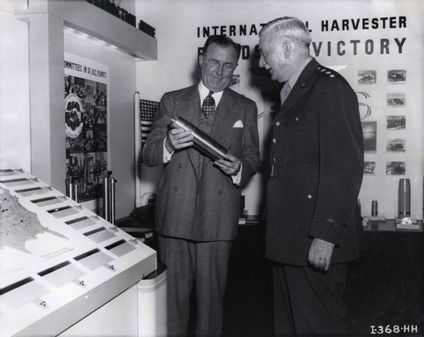 Charles E. Wilson, Executive Vice Chairman of the War Production Board and formerly president of General Electric Company, and Lieutenant General William S. Knudsen, Director of Production of the United States Army and formerly president of General Motors Corporation, inspect the Harvester Exhibit at the First National Labor-Management Exposition.