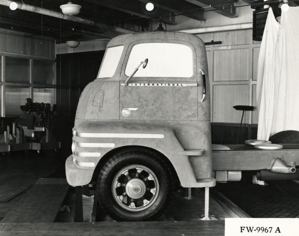 Side view of a full-size rendering of an International truck in clay.  The model is located inside a garage or studio space. The model was likely made by an industrial designer.