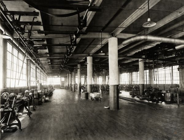 Interior view of the automatic machining department room in International Harvester's Milwaukee Works factory. Large windows line the walls. The machining room was located on the sixth story of Building #43.