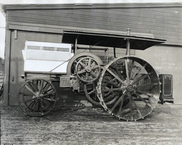 Left side view of an International Harvester 15-30 tractor parked in front of what appears to be a shed at the company's Milwaukee Works factory.