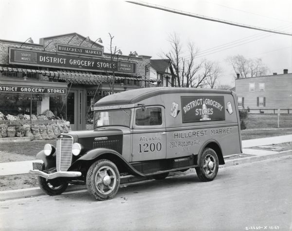 An International truck owned by the Hillcrest Market parked in front of the grocery store.
