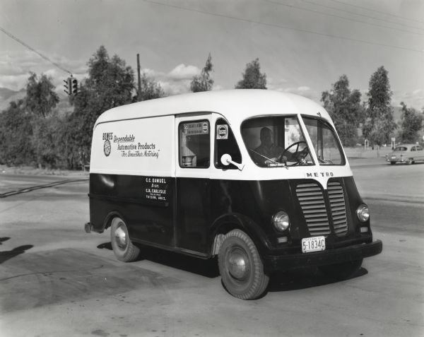 A man drives an International truck with Metro body owned by the Bowes Automotive Products company. The text on the side of the truck reads, "Bowes Dependable Automotive Products; For Smoother Motoring," "Seal-Fast," and "C.C Samuel, Dist.; C.R. Carlisle, Salesman."