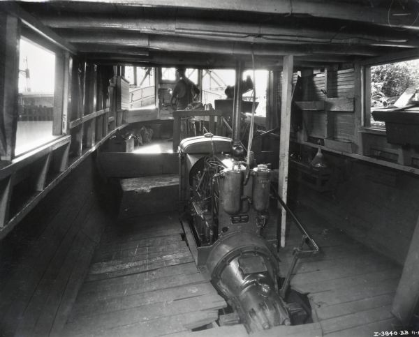 Interior view of a fishing boat powered by an International PD-40 power unit and owned by Julius Dettloff. A man stands at the boat's wheel.