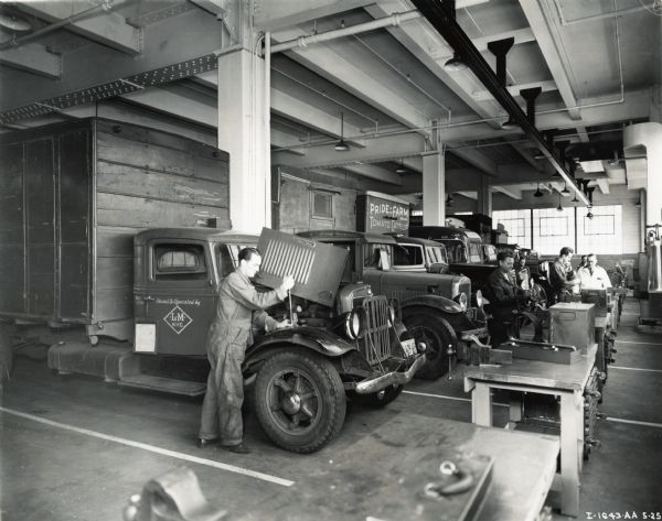 Men repair International trucks on the service floor of International's New York Manhattan truck branch.