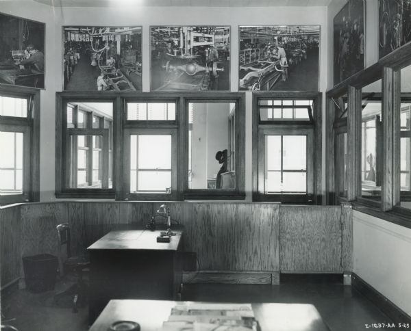 Reception room and general offices on the second floor of International Harvester's New York Manhattan truck branch. Large photographs of men at work in International's factories hang on the walls above interior windows.