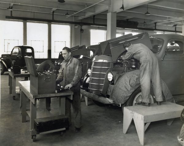 Men work on trucks in the pre-delivery service area on the third floor of International Harvester's Manhattan truck branch.