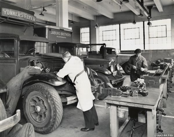 Men work on trucks in the second floor service department at International Harvester's Manhattan truck branch.