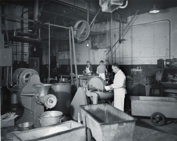 Men work in the meat processing room at Schwab & Company where machinery is powered by two International PA-50 power units and one PA-100 unit.