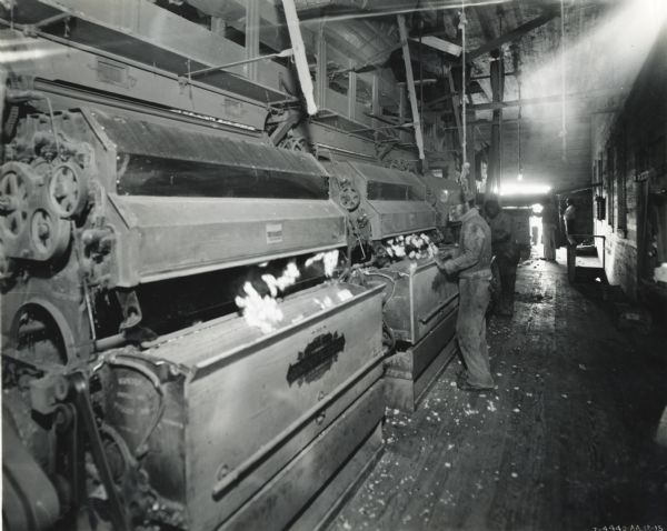 Workers tend machines inside the Long Short Gin. The machinery was powered by an International PD-80 power unit.
