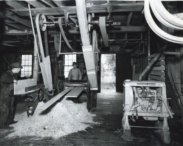 Workers operate machinery inside a woodworking shop. All equipment in the shop was powered by an International P-12 power unit.
