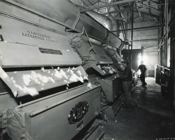 Workers operate machinery powered by an International PD-80 power unit at Siut-Me Gin Company.