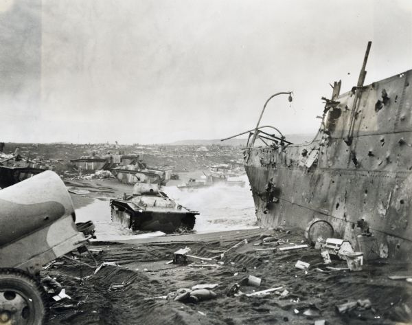 Parts of destroyed boats and military equipment on the shoreline of Iwo Jima on D-Day.