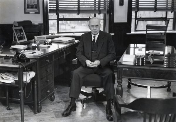 Mr. E.H. Sohner, General Superintendent of International Harvester's Bettendorf Works, wears a three-piece suit and sits in an office chair to pose for a portrait.