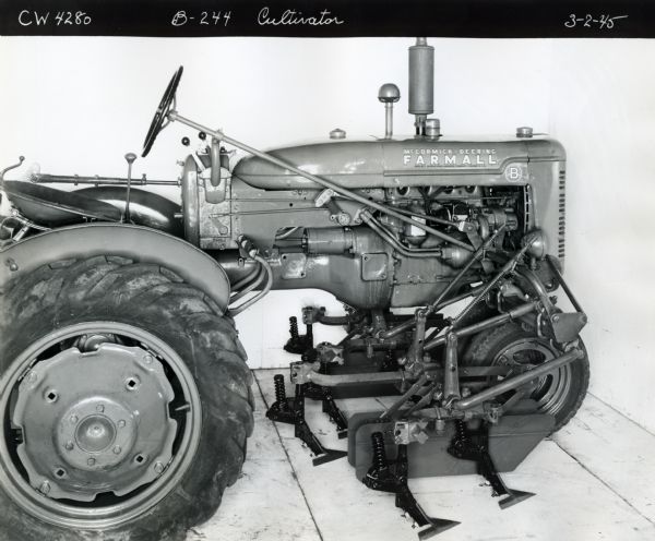 Engineering right side profile view of a Farmall B tractor with a B-244 cultivator.