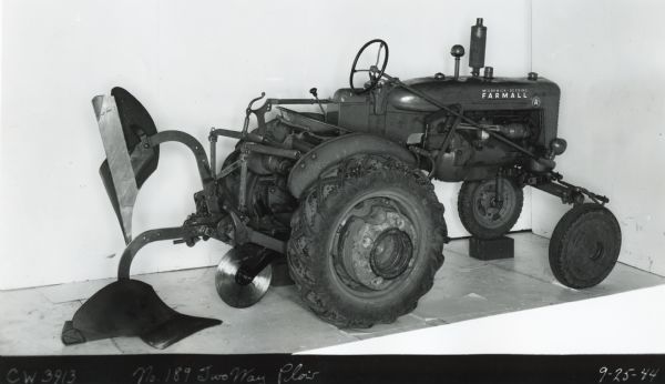 Engineering three-quarter view from right rear of a Farmall A tractor with a two-way plow attachment. The text on the bottom of the photograph reads: "No.189 Two Way Plow."