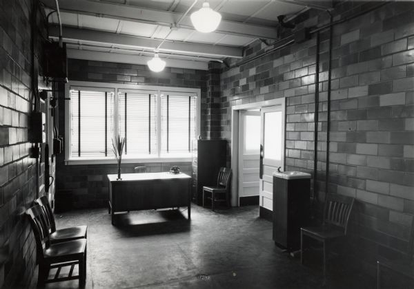 Interior view of chairs and a desk in the First Aid Reception Room at International Harvester's Quad Cities Tank Arsenal.
