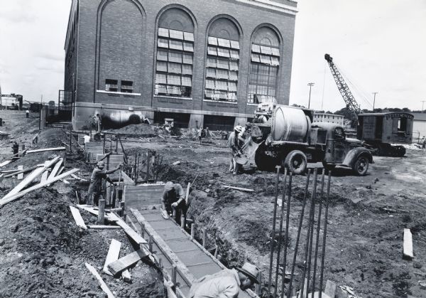 Men pouring and smoothing cement on the construction site of the Ordnance Steel Foundry Company. The Foundry may have served as part of International Harvester's war production.
