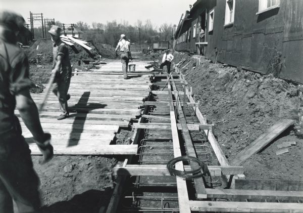 Men from contractor J.H. Hunzinger & Co. work on construction of the "Micro-Westco, Inc. plant addition." The addition may be part of International Harvester's Quad Cities Tank Arsenal.