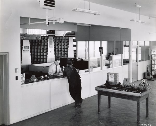Two men at a parts counter in an International Harvester dealership.
