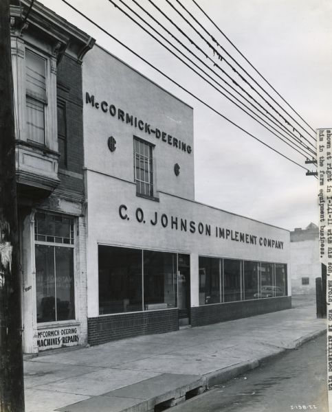 View from street of the storefront of C.O. Johnson Implement Company, an International Harvester dealership.