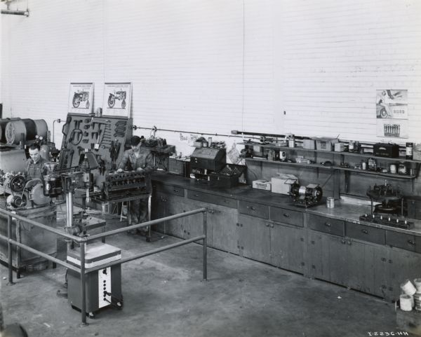 Mechanics working in a shop at the Bush-Ellis Implement Company, an International Harvester dealership. At the time of the photo, workers were in the process of rearranging the shop area.