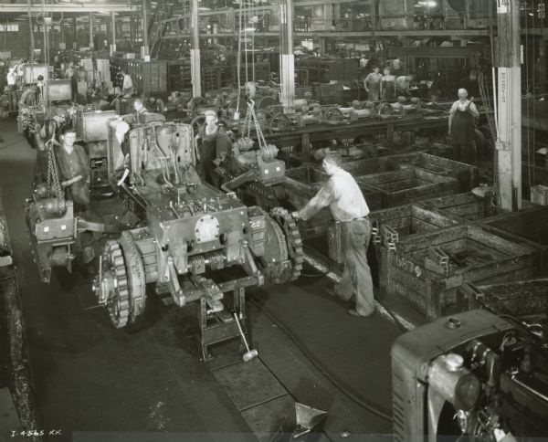 Factory workers on a crawler tractor (TracTracTor) assembly line at International Harvester's Tractor Works.