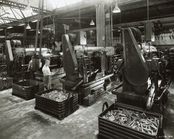Factory workers at large machines in International Harvester's Tractor Works.