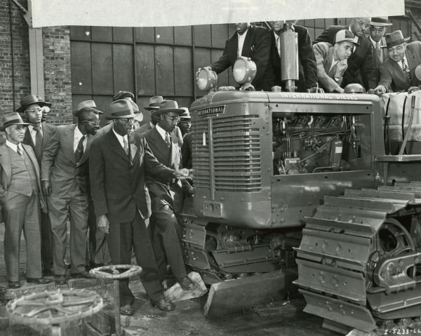 African-American farmers inspect an International crawler tractor (TracTracTor) at International Harvester's Tractor Works. The group was on a tour of the factory.