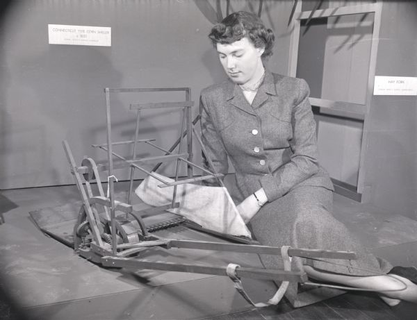 State Historical Society employee Joyce Hancock with a model of Cyrus McCormick's first reaper.